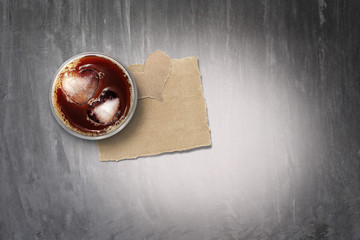 Iced coffee and torn paper on concrete  floor,color toned.Background for valentine's day.