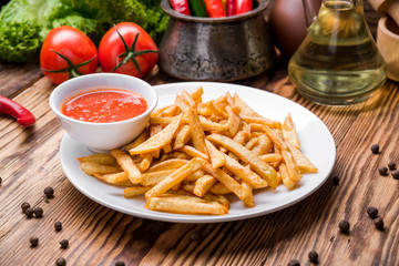 Tasty french fries on cutting board,  wooden table