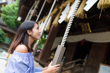 Fototapeta premium Woman holding the rope in Japanese temple