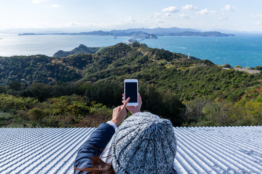 Woman using cellphone to take photo in Awaji island