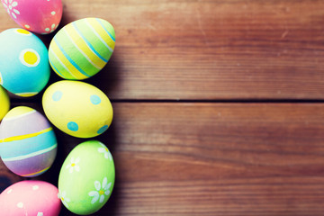close up of colored easter eggs on wooden surface