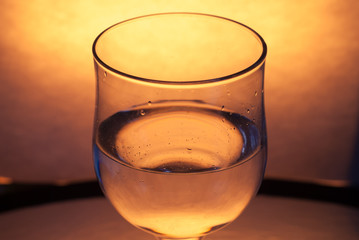 A glass of white wine on a bright yellow background,