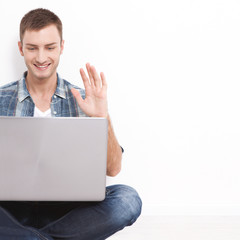 Young couple talking to each other via online video chat. Handsome man using a laptop for business...