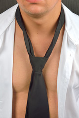 Picture of young man in a unbuttoned white shirt with black tie,