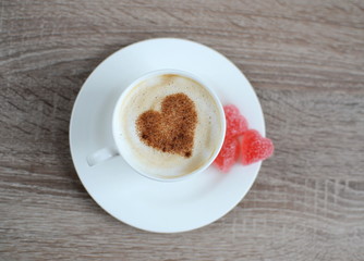 Cup of cappuccino with heart pattern of cinnamon