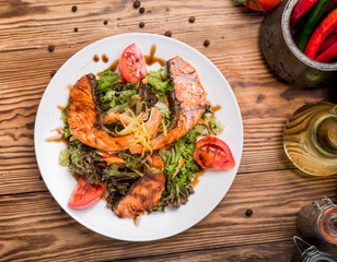 Salmon steak in white dish with vegetables