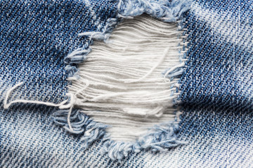 Fototapeta na wymiar close up of hole on shabby denim or jeans clothes