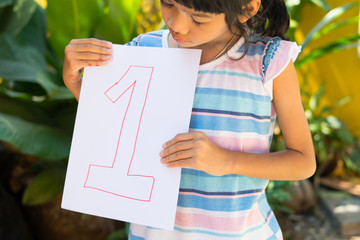 number concept,girl holding number 1 on white paper