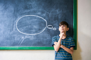 Boy Student Leaning On Blackboard And Thinking In Classroom