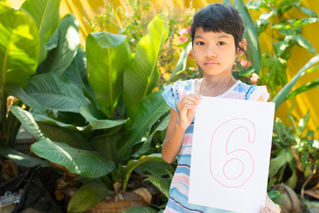 number concept,girl holding number six on white paper