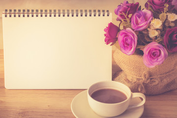 Happy weekend concept. White cup of coffee on wooden floor with purple flower in pot vintage color tone.
