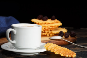 Coffee and waffles on dark wooden table