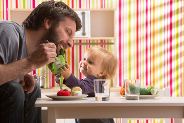 family baby daughter and dad play eat meal in toy kitchen