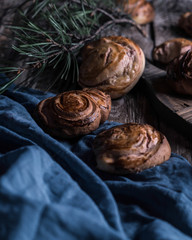Buns with white chocolate and raspberries on a wooden table with pieces of chocolate, berries and pine branches