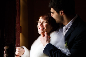 happy groom touches bride's chin tender