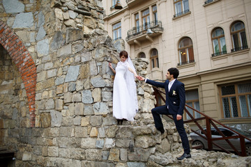 Fototapeta na wymiar Romantic newlywed couple near old castle walls