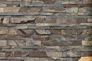 background decorative wall built of brown stone closeup