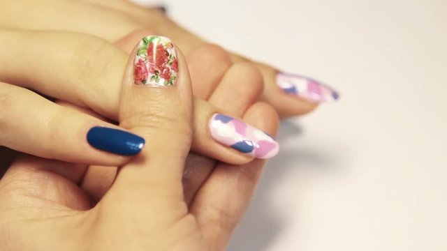 Cosmetic shop manicure session, woman hand painting colorful pattern on nail varnish, close up