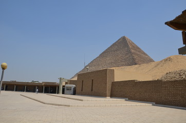 Pyramid in sand dust under gray clouds