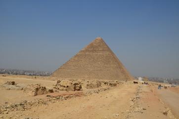Pyramid in sand dust under gray clouds