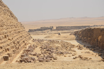 Pyramid in sand dust under gray clouds