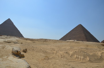 Pyramid in sand dust under gray clouds