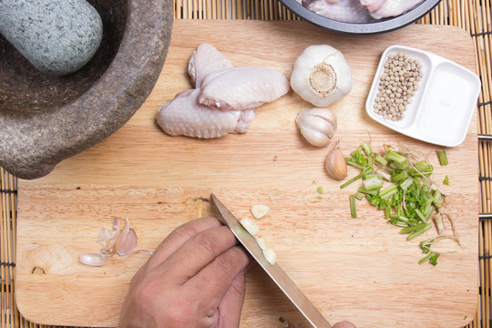 Chef slicing garlic with knife
