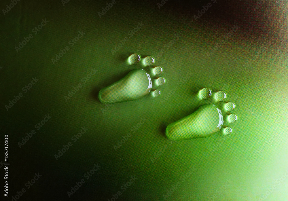 Poster traces feet foot from drops on a green background close-up macro. water drops dew rain in the form o