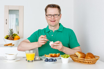 Mann isst ein Ei zum Frühstück