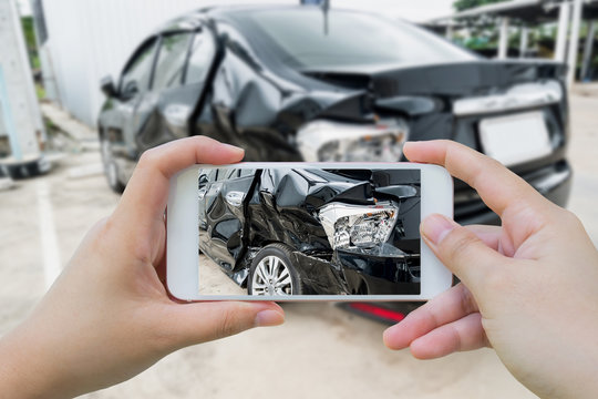 Car crash accident damaged with hand using smartphone taking pho