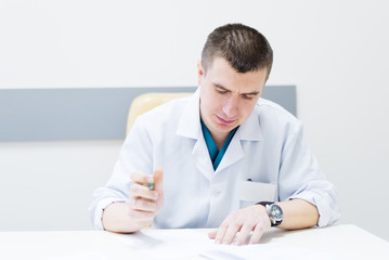 Doctor writes on a desk in the office