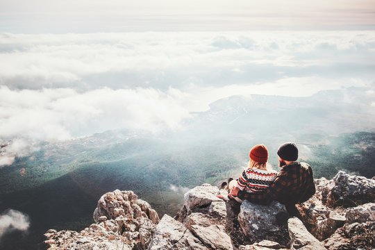 Couple travelers Man and Woman sitting on cliff relaxing mountains and clouds aerial view  Love and Travel happy emotions Lifestyle concept. Young family traveling active adventure vacations
