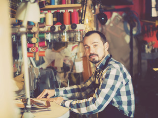 Fototapeta na wymiar Hard-working man working on stitches for belt
