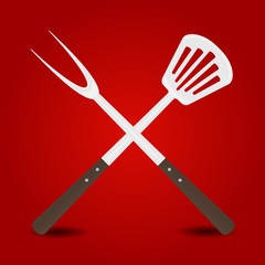 Crossed big fork and spatula on red background
