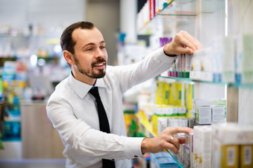 Smiling male customer looking for right medicine