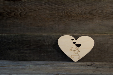 Enamoured cats on a background of a wooden heart