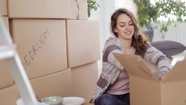 Woman packing carton box for moving