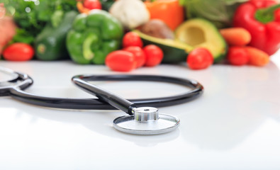 Variety of vegetables and stethoscope on white background