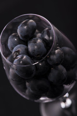 Glass filled with red ripe grapes