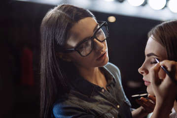 Professional female makeup artist putting on eyeshadow