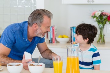 Father interacting with son while having breakfast 