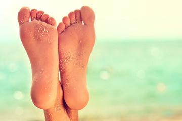 Perfect schone vrouwelijke voeten met zeezand op het strand. Spa, scrub en voetverzorging. Voet massage .
