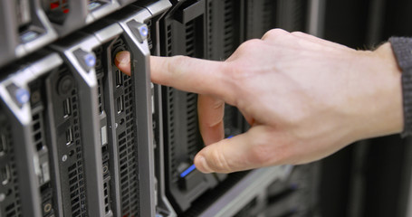 IT consultant power on a blade server in datacenter