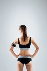 Fototapeta na wymiar Slim woman posing on a grey background after training