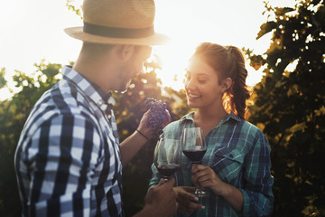 People sampling and tasting wines in vineyard