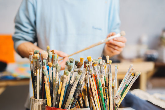 Paint Brushes on a blur background and artist is holding the brush