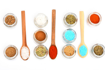 various spices in spoons and jars on white background