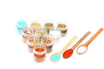 various spices in spoons and jars on white background