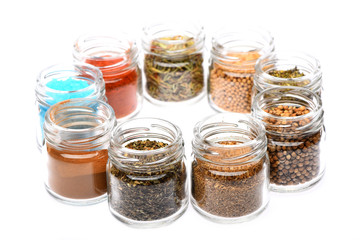 various spices in jars on white background
