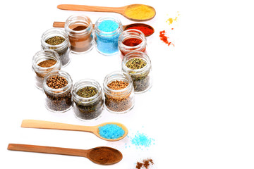 various spices in spoons and jars on white background